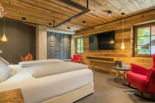 a bedroom with a large bed and a flat screen tv at Boutique Hotel beim Lipp - Restaurant & Spa in Roßhaupten