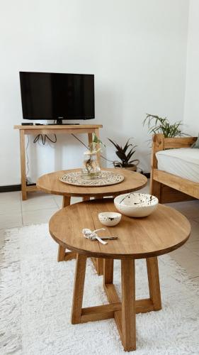 two wooden tables in a living room with a tv at Casa Soul in Chascomús