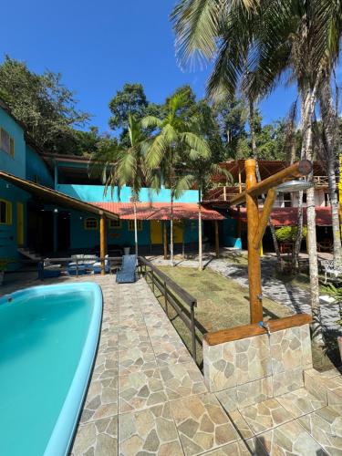 a resort with a swimming pool and palm trees at Pousada Tropical Araçatiba in Praia de Araçatiba