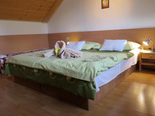 a bed with a stuffed animal sitting on top of it at Rekreacny Dom in Strečno