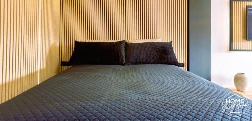 a bedroom with a blue bed with a striped wall at Home Sweet House in Hermée