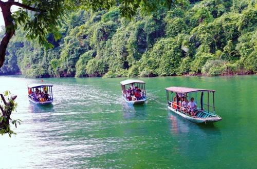 two boats in a river with people on them at Nam Pé Tày Homestay - View hồ Ba Bể in Bak Kan