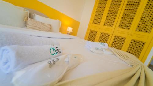 a white bed with towels on top of it at Lappartement de la Marina: Vue mer et port in Yasmine