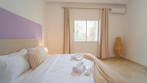 a bedroom with a white bed with a window at Lappartement de le Marina 2 : Vue mer et port in Yasmine