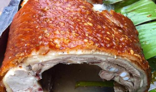 a piece of meat on a plate with vegetables at Nam Pé Tày Homestay - View hồ Ba Bể in Bak Kan