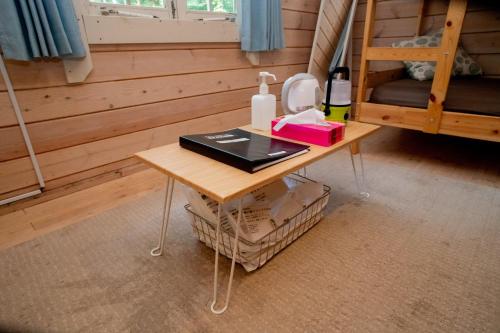 a small table in a room with a bunk bed at 森と湖の楽園ＷorkshopＣampＲesort in Fujikawaguchiko