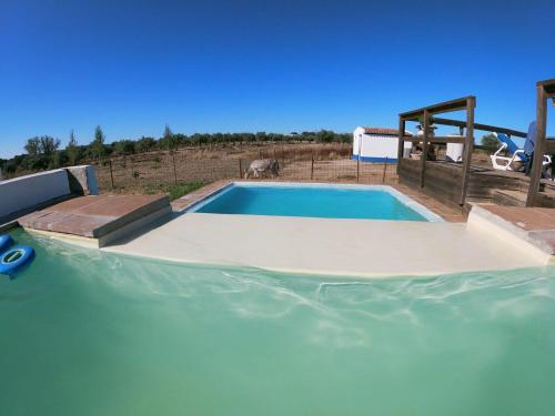 a swimming pool in the middle of a field at Herdade do Corval in Reguengos de Monsaraz