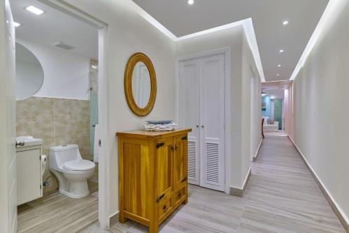 a bathroom with a toilet and a sink and a mirror at Costa Del Sol Juan Dolio 2BR Sunset, Beach Front in Juan Dolio