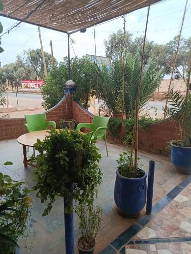 a patio with chairs and a table and potted plants at Africa Hollywood in Aït Ben Haddou