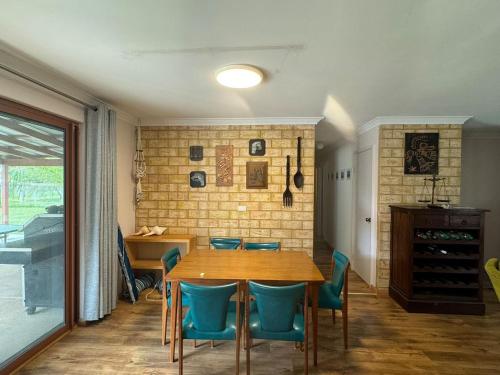 comedor con mesa de madera y sillas azules en Sandy Paws and Salty Air, en Lancelin