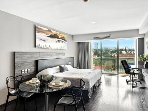 a bedroom with a bed and a table and chairs at Elite 47 Interlomas in Mexico City