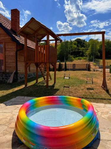 a rainbow colored frisbee in front of a playground at Vikendice Jovicic in Bukorovac