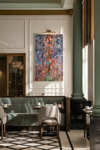 a large painting on the wall in a restaurant with chairs at Giza Palace Hotel & Spa - The Leading Hotels Of The World in 6th Of October