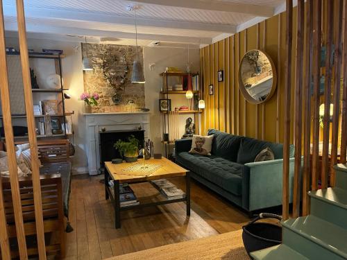 un salon avec un canapé vert et une table dans l'établissement La maison bleue, à Pont-Aven