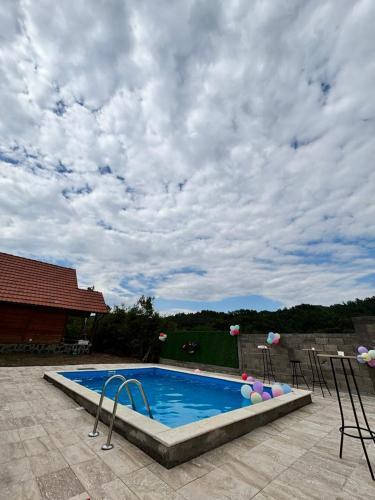 a swimming pool under a cloudy sky at Vikendice Jovicic in Bukorovac