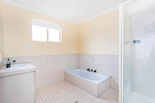 ein Badezimmer mit Badewanne, Waschbecken und Dusche in der Unterkunft Saltwater Sanctuary, by the sea in Ledge Point