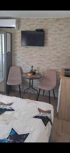 a room with a bed and a table and chairs at Apartman Živković in Leskovac