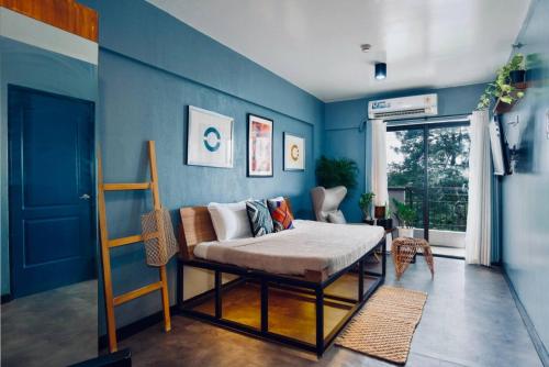 una camera da letto con un letto e una parete blu di Functional stay near airport, business districts a Manila