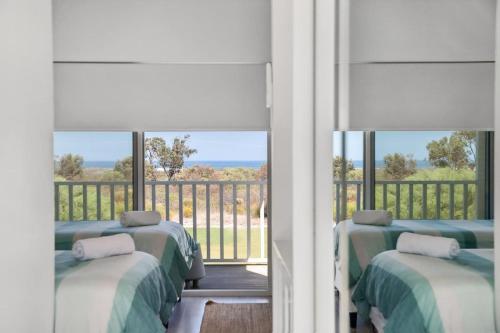 a room with four beds and a balcony with a view at Stunning Lookout Lancelin in Lancelin