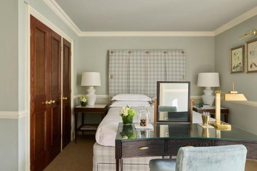 a bedroom with a bed with a desk and a mirror at Milestone Hotel Kensington in London