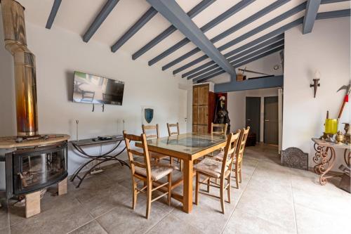 - une salle à manger avec une table, des chaises et un poêle à bois dans l'établissement Atypical house with breathtaking city views, à Carcassonne