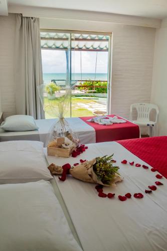 a hotel room with two beds with roses on the bed at Hotel Paraiso Natal - Beira Mar in Natal