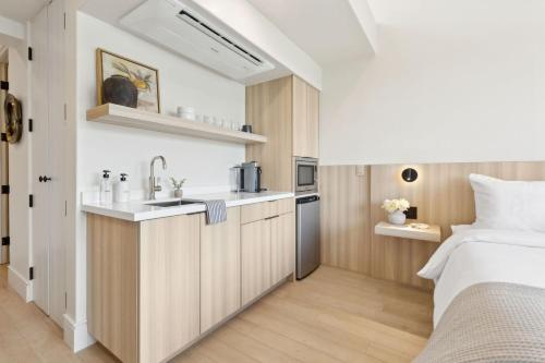 a bedroom with a bed and a kitchen with a sink at Casa Riviera - Boutique Suites in Downtown Santa Barbara in Santa Barbara