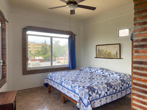 a bedroom with a bed and a window at Casitas Las Palmas - Coral Azul in Punta Mita