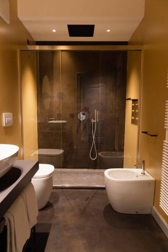 a bathroom with a shower and a toilet and a sink at VIS Urban Suites&Spa in Bari