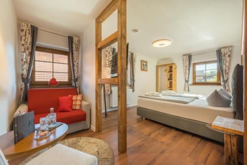 a living room with a bed and a table at Boutique Hotel beim Lipp - Restaurant & Spa in Roßhaupten