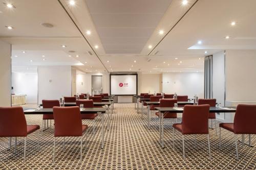 a conference room with tables and chairs and a screen at Exe Plaza in Madrid