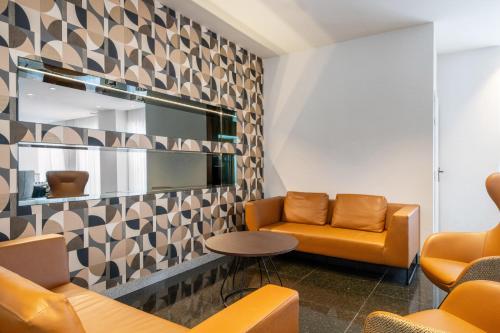 a waiting room with orange chairs and a mirror at Exe Plaza in Madrid