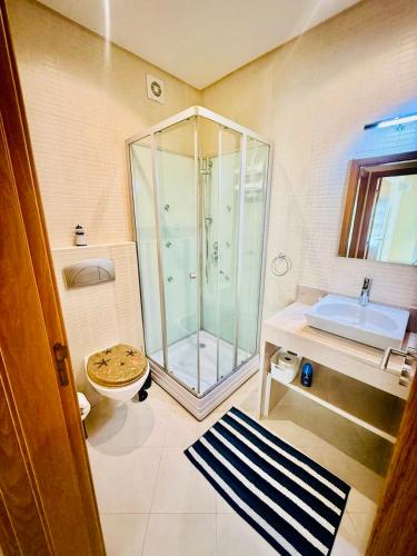 a bathroom with a shower and a toilet and a sink at Luxury 2 bed Carvoeiro in Carvoeiro