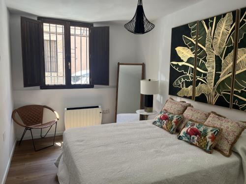 a bedroom with a bed with a large painting on the wall at Apartamento Blancanieves in Brihuega