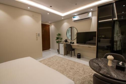 a bedroom with a bed and a desk and a mirror at فندق لوكسري سويتس- Luxury Suites Hotel in Taif