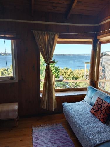 a bedroom with a bed and a large window at Cabaña Génesis in Puyehue
