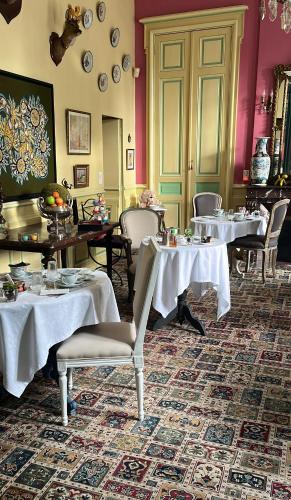 a restaurant with tables and chairs with white table cloth at Hôtel Château des Jacobins in Agen