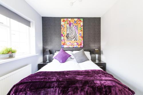 a bedroom with a bed with a purple blanket at Verve Hotel in Bedford