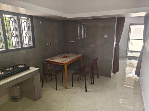 a kitchen with a table and chairs in a room at Treva Breeze Villa 2BHK in Kīl Kāsākkudi