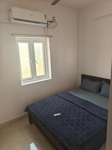 a bedroom with a bed and a window at Treva Breeze Villa 2BHK in Kīl Kāsākkudi