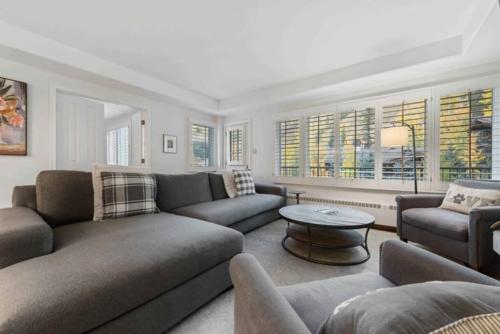 a living room with couches and a table and windows at Lodge Tower 487 Two Bedroom Residence in Vail