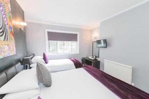 a hotel room with two beds and a window at Verve Hotel in Bedford