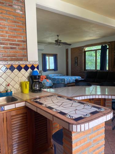 a kitchen and living room with a brick wall at Casitas Las Palmas - Coral Azul in Punta Mita