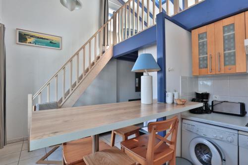 a kitchen with a table and a stairway at Hôtel & Appart-hôtel Olatua in Bidart
