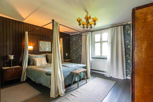 a bedroom with a canopy bed and a window at Kłodnia 1 in Rytel