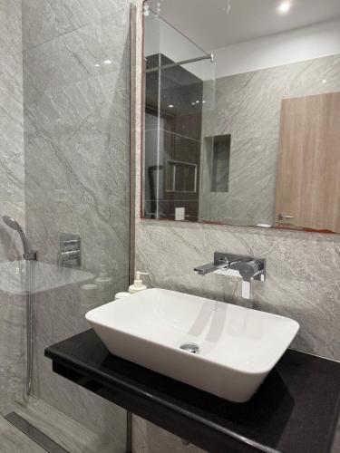a bathroom with a white sink and a shower at Vironas Hotel in Himare