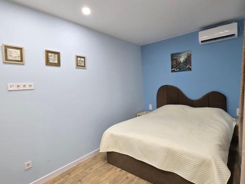 a bedroom with a bed with a blue wall at Summer House with Private Pool in K'obulet'i