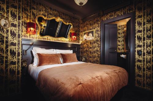 a bedroom with a large bed with gold wallpaper at Madame C - Hôtel très particulier in Strasbourg