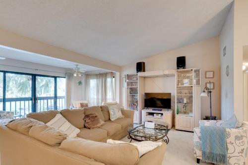 a living room with a couch and a tv at Pool and Ocean Access Palm Beach Gardens Condo in Palm Beach Gardens