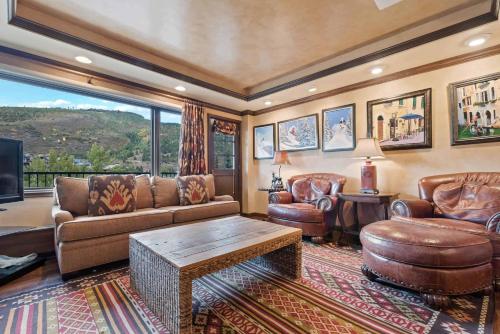 a living room with leather furniture and a large window at Lodge Tower 494 Two Bedroom Residence in Vail